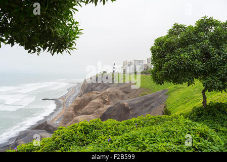 Dramatische Küstenlinie in Lima Miraflores von oben gesehen. Wintersaison, bewölkt und neblig Himmel, Ozean winken. Skyline in der backg Stockfoto