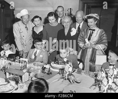 David Eisenhower bläst die Kerzen auf seine Geburtstagstorte. 31. März 1956. Teilnahme an seiner weißen Haus Geburtstagsparty sind Schauspieler Roy Rogers und Dale Evans und 25 Kinder. Stehende L-r: Roy Rogers, die First Lady, Barbara und John Eisenhower, Elivera Doud, Präsident, Dale Evans. -(BSLOC 2014 16 109) Stockfoto