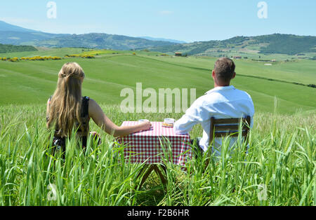 Ein paar am Tisch mitten in einem toskanischen Feld. Italien Stockfoto