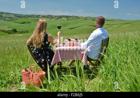 Ein paar am Tisch mitten in einem toskanischen Feld. Italien Stockfoto