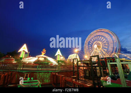 Vergnügungspark mit Riesenrad in Bewegung Stockfoto