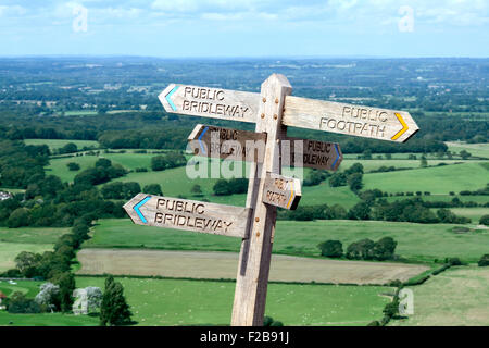 Wanderweg-Wegweiser in sechs Richtungen auf den South Downs in der Nähe von Devil es Dyke, West Sussex. Mit schöner Aussicht in den Hintergrund. Stockfoto