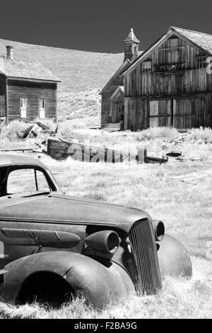 Auto und historische Holzbauten in Bodie State Historic Park einer kalifornischen Goldminen-Geisterstadt aufgegeben. Stockfoto