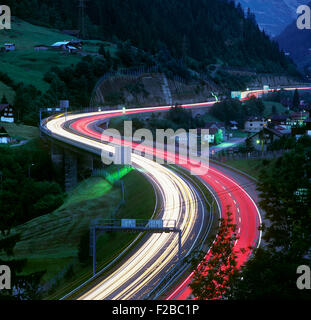 Nachtansicht von Lichtspuren auf der Schweizer A2 Autobahn in der Nähe von Wassen, Blick nach Süden in Richtung St. Gotthard-Tunnel. Stockfoto