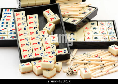 Mahjong, Mah Jong spielen, öffnen mit Inhalt teilweise entfernen. Verschiedene schwarze Trays mit Sets oder Klagen von Karten und Fliesen mit weißen Hintergrund. Stockfoto