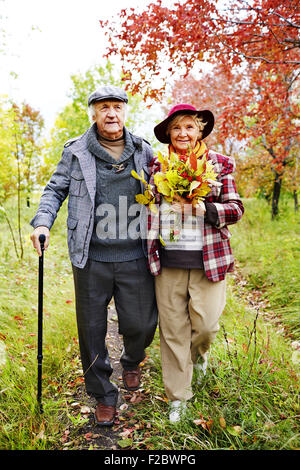 Ehepaar im Ruhestand warm Casualwear Wandern im Park zur freien Verfügung Stockfoto