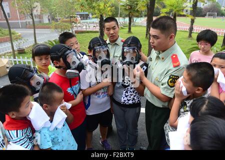 Hefei, China Anhui Provinz. 16. Sep, 2015. Feuerwehr unterrichten Schüler wie Gasmasken während einer Räumungsübung in Huangshan Straße Grundschule in Hefei, Hauptstadt der ostchinesischen Provinz Anhui, 16. September 2015 zu verwenden. © Liu Junxi/Xinhua/Alamy Live-Nachrichten Stockfoto