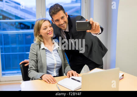 Porträt von zwei Lächelnde Geschäftsleute nehmen ein Selbstporträt mit smartphone Stockfoto