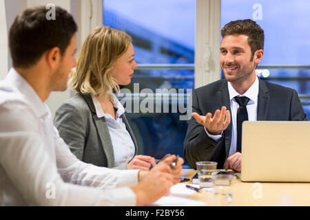 Unternehmerinnen und Unternehmer streiten über Konferenztisch Stockfoto