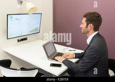 Geschäftsmann mit Laptop im Konferenzraum Stockfoto