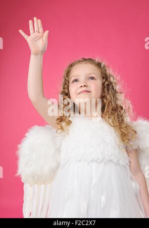 Schöne kleine Engel Mädchen auf rosa Hintergrund isoliert Stockfoto