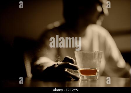 Rauchende Frau mit einem Glas Whisky und Zigarre Stockfoto