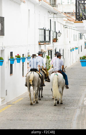 Männer auf Pferden tragen Cordobes Hüte in traditioneller Tracht in weißen andalusischen Dorf während der Feria von Mijas Andalusien, Spanien. Stockfoto