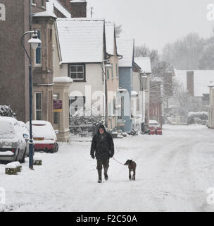 Presteigne, Powys, Mitte Wales, UK. Die Stadt mitten im Winter. Eine Frau, die ihren Hund Stockfoto