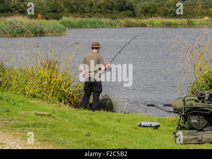 Mann angeln auf Bank von Longham Seen, Ferndown, Dorset, England, Großbritannien Stockfoto