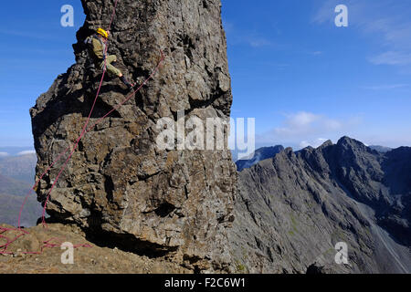 Ein Kletterer Abseilen der unzugänglichen Pinnacle auf dem Grat Cuillin, Skye, Schottland Stockfoto