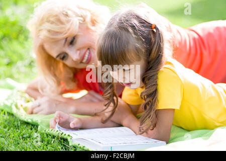 Mutter, einem Buch, im Freien im Sommer kid Stockfoto