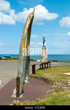 Der Fischbein-Bogen auf der West Cliff, Whitby, Yorkshire, England, UK. Die Statue von Captain Cook ist hinter. Stockfoto