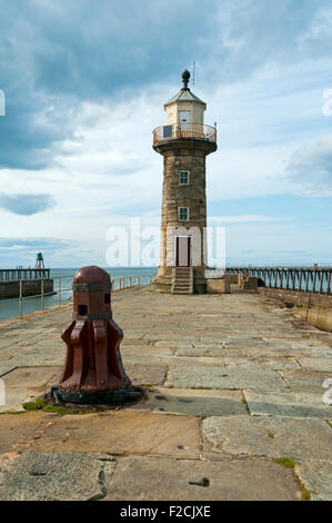 Alten Capstan und Leuchtturm an der Pier von Whitby Osthafen, Whitby, Yorkshire, England, UK Stockfoto