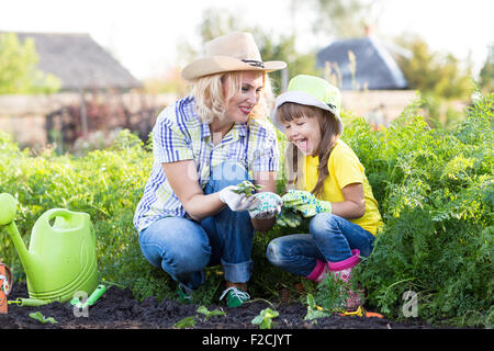 Mutter und Mädchen Pflanzung Erdbeerpflanzen im Sommer Stockfoto