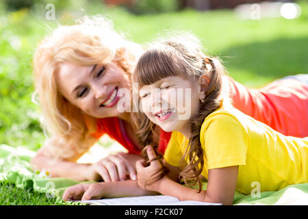 Kind mit Picknick und Lesebuch im Sommerpark Stockfoto