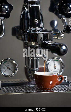 Edelstahl-Espresso-Maschine in Aktion mit braunen Espressotasse Stockfoto