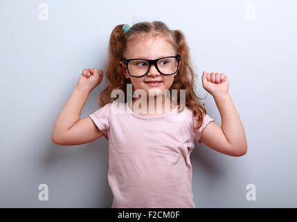 Starke glücklich erfolgreichen Mädchen zeigen muskulöse in Gläsern. Gesundes Kind Lebensstil. Closeup portrait Stockfoto