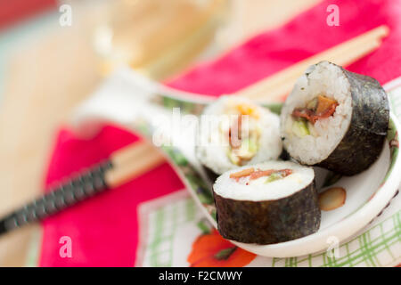 Vegane Sushi-Rollen auf einem Teller mit Stöcken Stockfoto