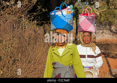 Zwei madagassischen Frauen mit Einkaufstasche auf ihren Kopf zu Fuß zum Wochenmarkt in Ambalavao, Haute Matsiatra, Madagaskar, Afrika Stockfoto