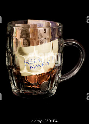 Bier-Ersparnisse in ein Pint Glas auf schwarzem Hintergrund Stockfoto