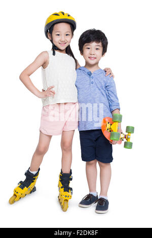 Kleines Mädchen auf Rollschuhen und junge hält eine skateboard Stockfoto