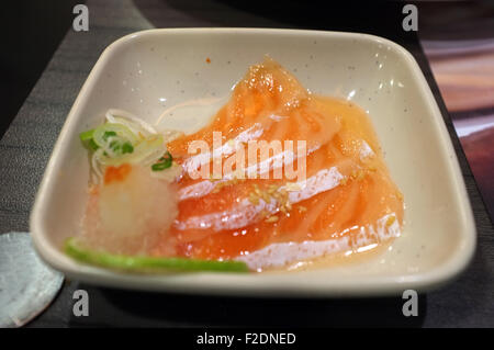 Scheibe von roher Lachs in würziger Salat-sauce Stockfoto