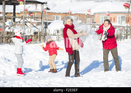 Glückliche Familie mit einer Schneeballschlacht im Schnee