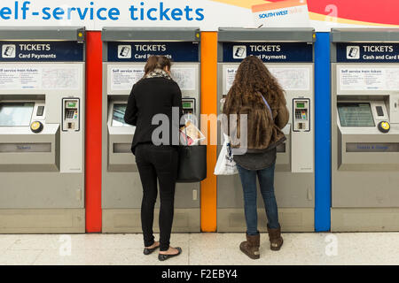 Zwei weibliche Reisende kaufen Bahntickets bei self service Ticket Maschine, London Waterloo Bahnhof, UK Stockfoto