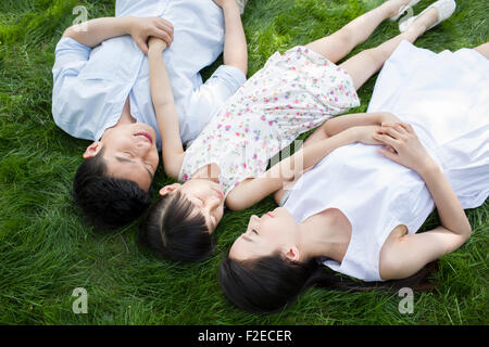 Glückliche junge Familie liegen auf dem Rasen