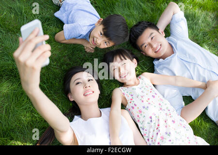 Glückliche junge Familie liegen auf dem Rasen Stockfoto