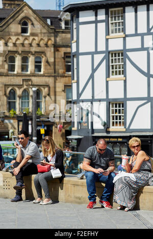 Menschen entspannen in der Sonne am Manchester Stadtzentrum Exchange Square UK Großbritannien britische Großbritannien Europa Europäische Stockfoto