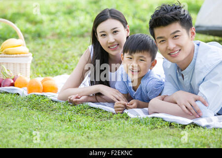 Glückliche junge Familie Picknick auf dem Rasen
