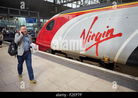 Manchester Piccadilly Bahnhof natives Senderlogo in einem Pendolino-Zug aus London Passagiere vorbei verschwommen zu Fuß zum Mann Stockfoto