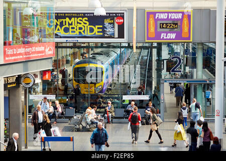 Manchester Piccadilly Station Bahnfahrgäste in der Bahnhofshalle mit He-Zug durch er sichtbar Glas Passagiere vorbei an P Stockfoto