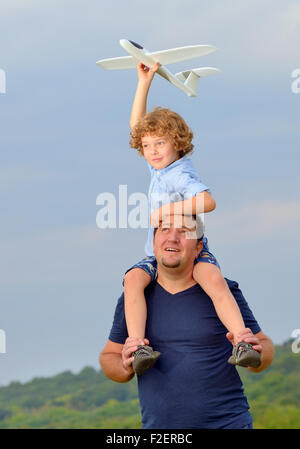 Vater, Sohn und sein Flugzeug auf Schultern tragen Stockfoto