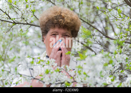 Frau mit allergischer Rhinitis im Frühlingsgarten Stockfoto