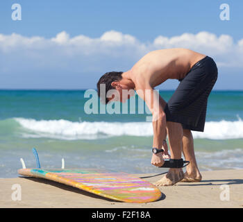 Surfer trägt Sicherheitsleine bis zum Knöchel am Strand Stockfoto