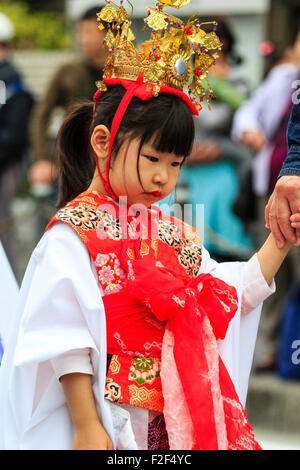 Genji Tada Heiligtum Festival. Parade der Kinder in der Heian-zeit Kostüm. Junge Mädchen, 6-8 Jahre alt, mit Gold Crown, weißes Gewand und roter Jacke. Stockfoto