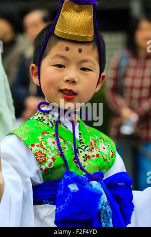 Genji Tada Heiligtum Festival. Parade der Kinder in der Heian-zeit Kostüm. Junge Junge, 6-8 Jahre alt, mit goldenen Hut, weißes Gewand und grüne Jacke. Stockfoto