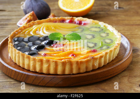 Obstkuchen mit verschiedenen Beeren (Trauben, Pfirsiche, Kiwi, Orange) Stockfoto