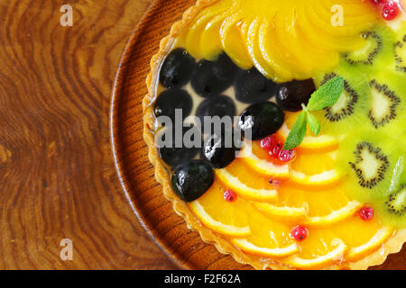 Obstkuchen mit verschiedenen Beeren (Trauben, Pfirsiche, Kiwi, Orange) Stockfoto