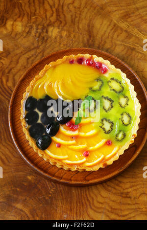 Obstkuchen mit verschiedenen Beeren (Trauben, Pfirsiche, Kiwi, Orange) Stockfoto