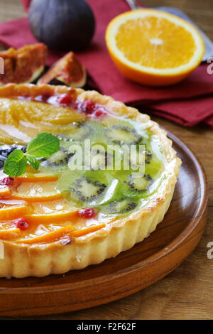 Obstkuchen mit verschiedenen Beeren (Trauben, Pfirsiche, Kiwi, Orange) Stockfoto