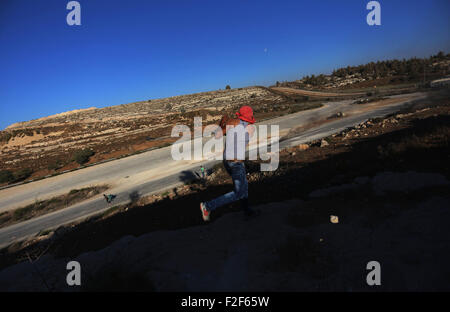 Ramallah, Westjordanland, Palästinensische Gebiete. 17. Sep, 2015. Ein palästinensischer Demonstrant wirft Steinen auf israelische Sicherheitskräfte während der Auseinandersetzungen nach einer Demonstration in Solidarität mit den Demonstranten an der Al-Aqsa Moschee Verbindung in der Jerusalemer Altstadt, außerhalb der Verbindung der israelischen Ofer Militärgefängnis, in der Nähe von West Bank Stadt von Betunia, am 17. September 2015. Saudi Arabien verurteilte am Donnerstag die Menschenrechtsverletzungen durch die israelischen Streitkräfte der Jerusalemer al-Aqsa Moschee, eine der heiligsten Stätten des Islam, die Tage von Zusammenstößen zwischen Polizei und Steinwürfe Palästinenser (Credit gesehen hat Stockfoto